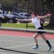 Female tennis player in action on court.