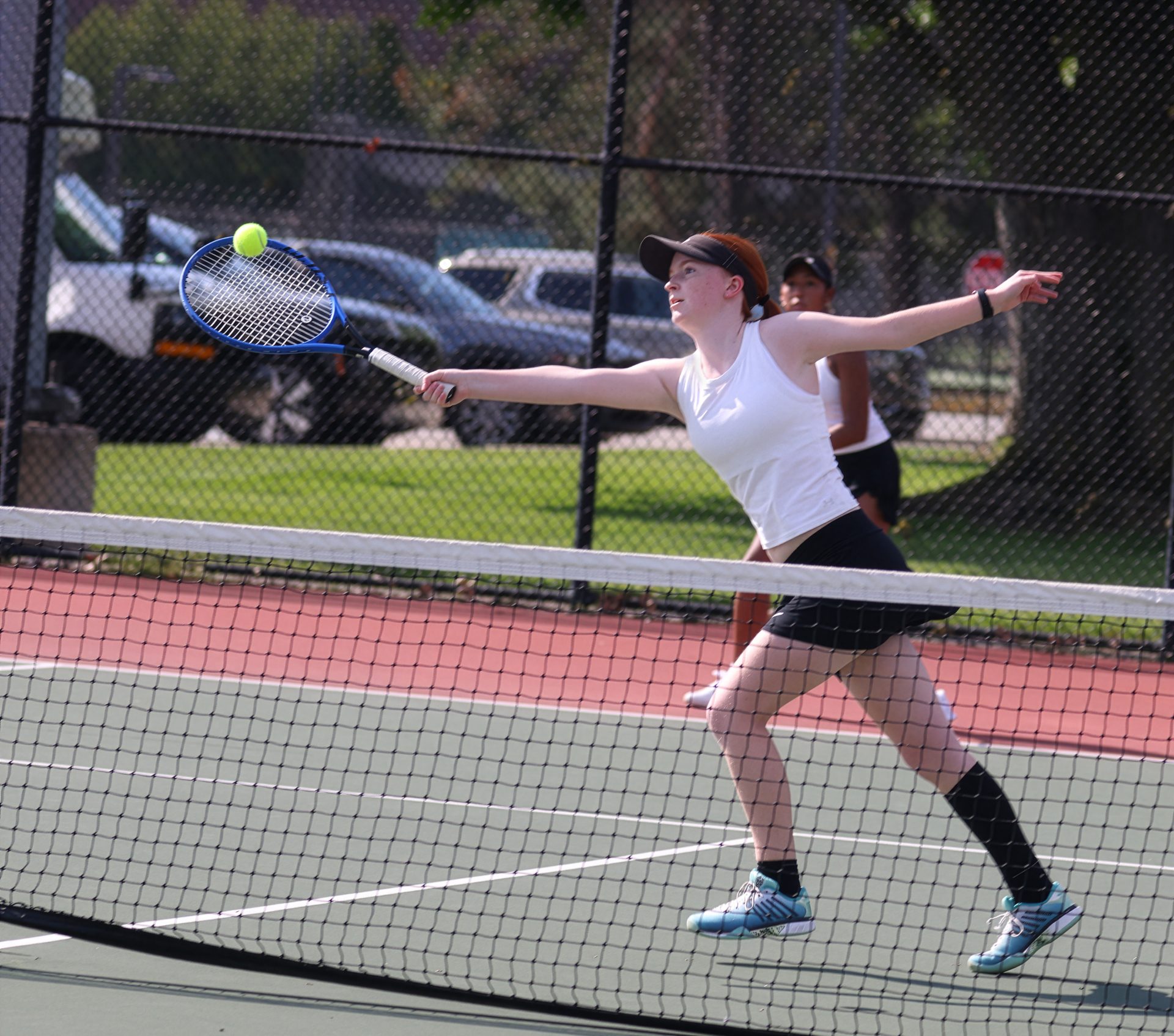 Female tennis player in action on court.