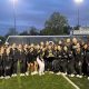 Penn Girls Track & Field team posing with a trophy on a track infield.