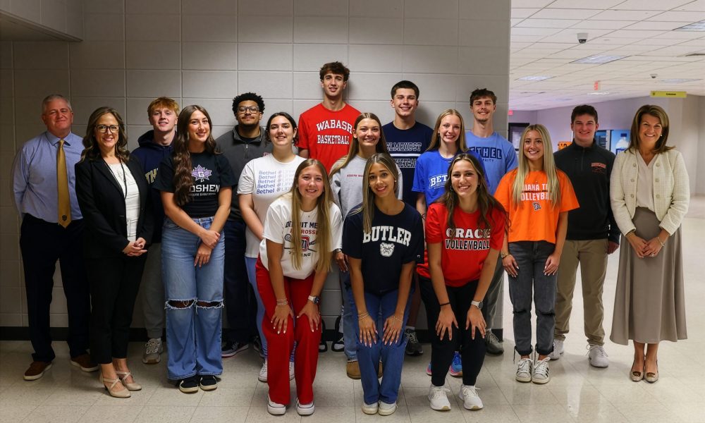 Group of people posing for a photo in front of a classroom.
