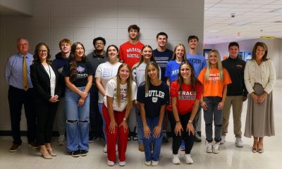 Group of people posing for a photo in front of a classroom.