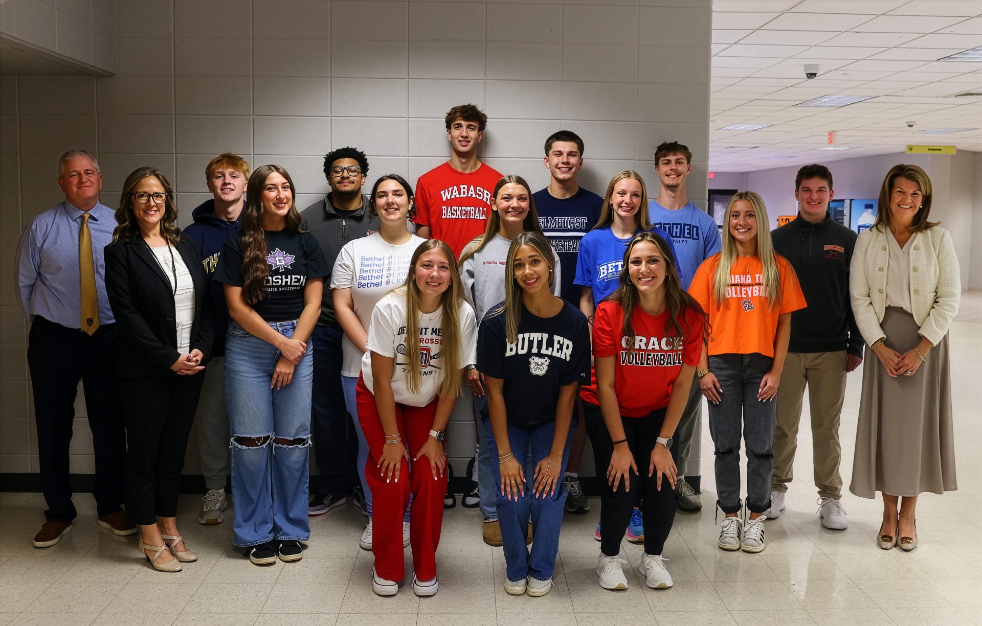 Group of people posing for a photo in front of a classroom.