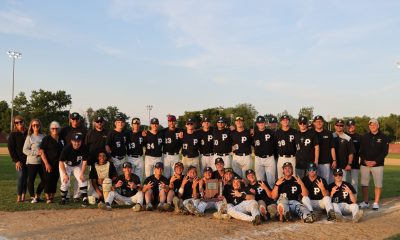 Baseball team posing for a group picture on a field.