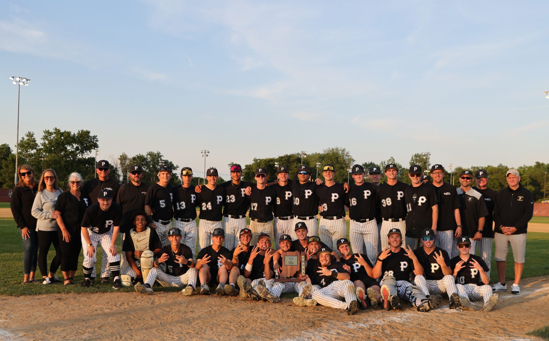 Baseball team posing for a group picture on a field.