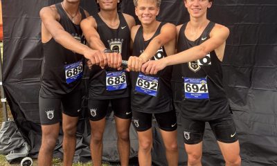 Four athletes posing together, celebrating their victory in a race.