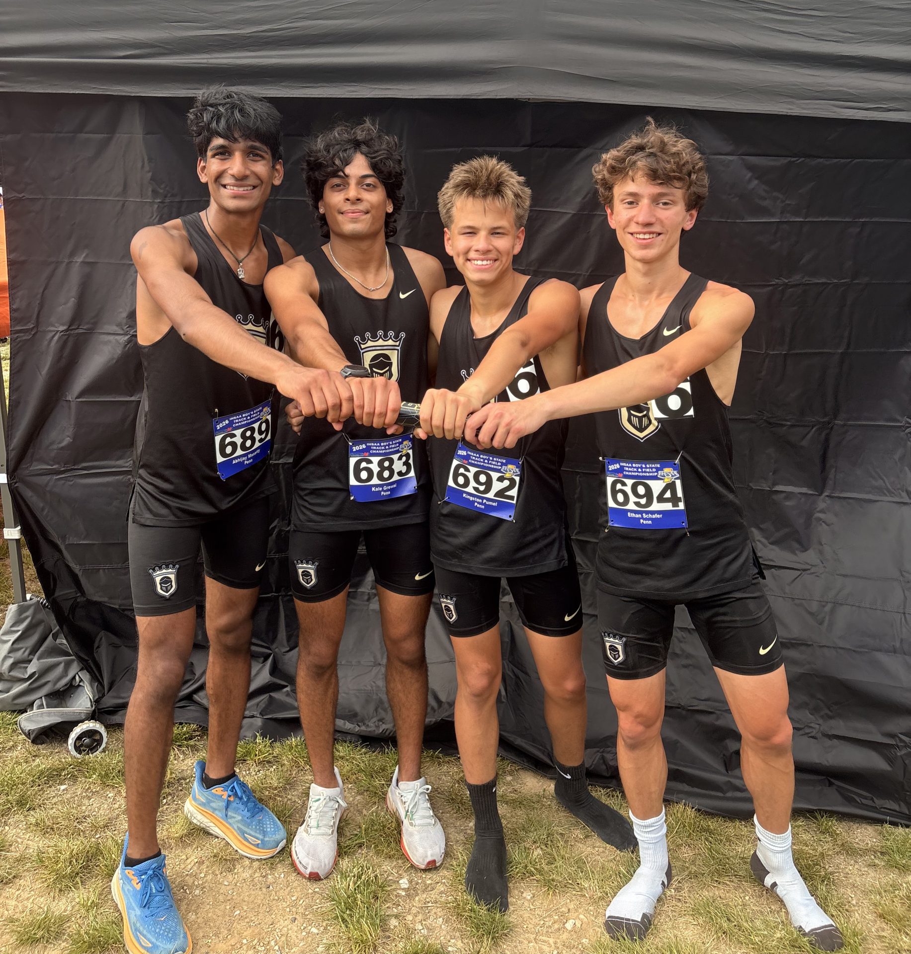 Four athletes posing together, celebrating their victory in a race.