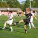 A soccer player kicks the ball.