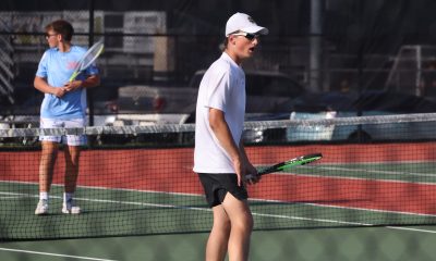 A tennis player stands on a tennis court.