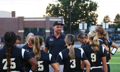 A football coach talks to a team on the field.
