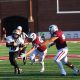 A football player runs the ball.