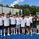 Boys tennis players pose for a photo on a tennis court.