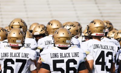 Football team on field, all wearing uniforms.