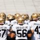 Football team on field, all wearing uniforms.