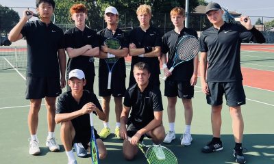 A tennis team poses with a trophy.