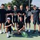 A tennis team poses with a trophy.