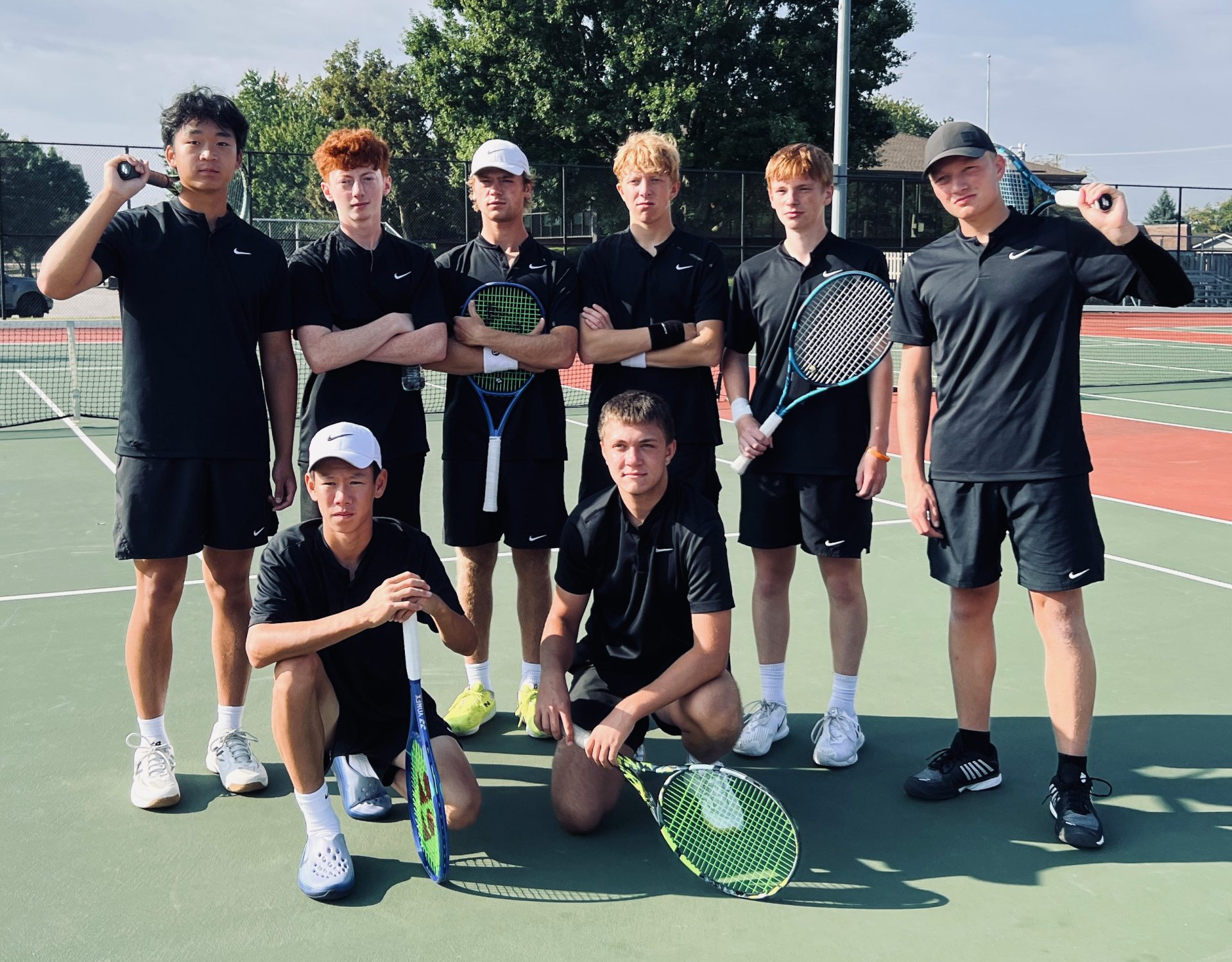 A tennis team poses with a trophy.