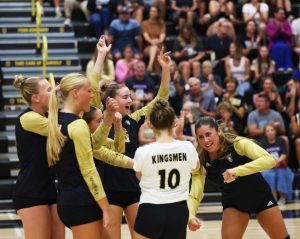 Volleyball players celebrate a point.