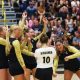 Volleyball players celebrate a point.