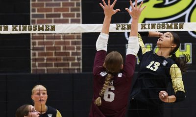 A volleyball players jumps up to hit the ball.