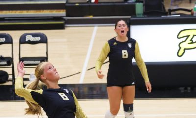 Two female volleyball players in action on a court.