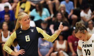 A volleyball player poses for a photo on the court.
