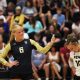 A volleyball player poses for a photo on the court.