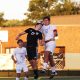 Two soccer players leap for the ball.