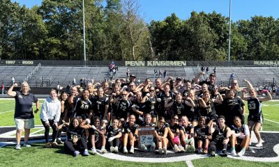 A group of people posing for a photo on a football field.