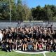 A group of people posing for a photo on a football field.