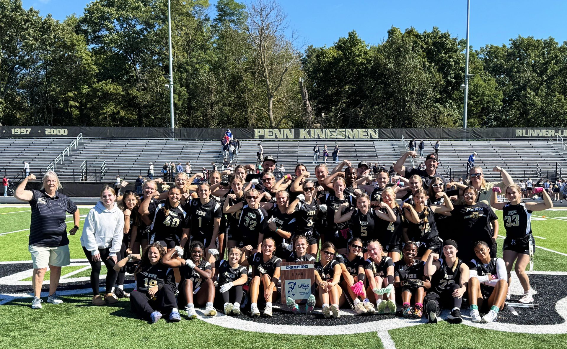 A group of people posing for a photo on a football field.