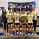 A group of runners posing on a stage with their medals.